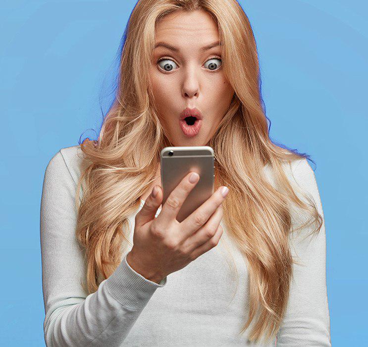 Blonde female looking into phone with surprised expression on face